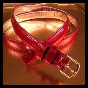Red patent leather belt with gold buckle.